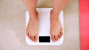A person standing on a white digital bathroom scale.